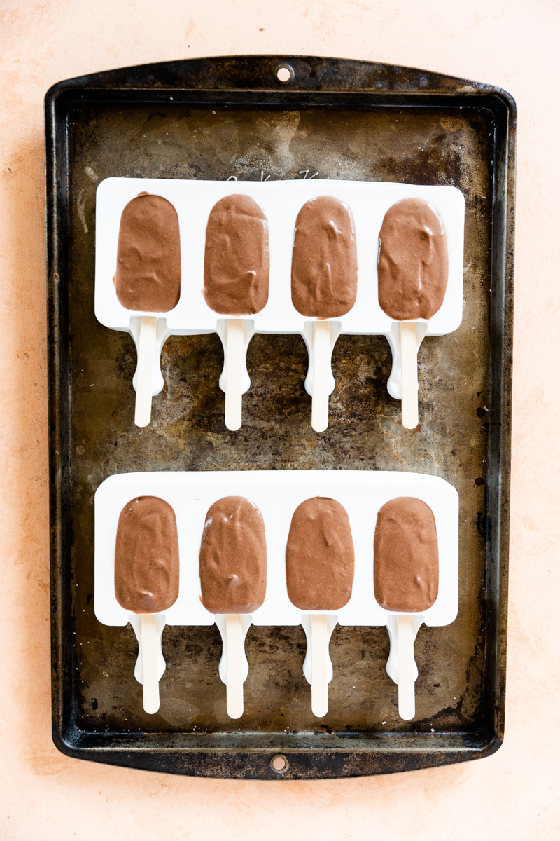 Popsicle molds filled with chocolate mixture.