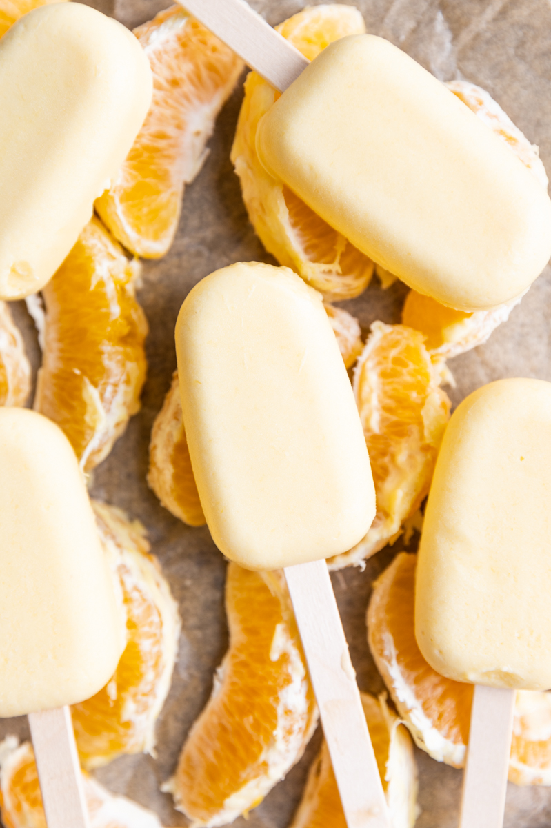 Overhead picture of ice cream bars on orange slices.