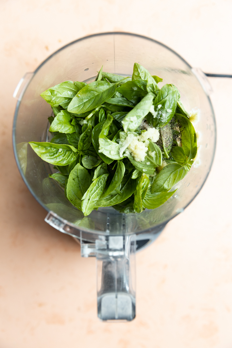 Pesto ingredients in a food processor.