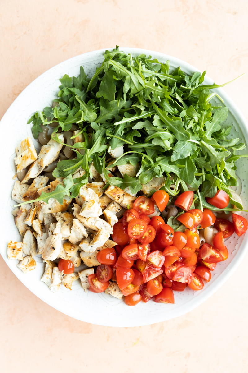 All pasta salad ingredients in bowl before stirring together.