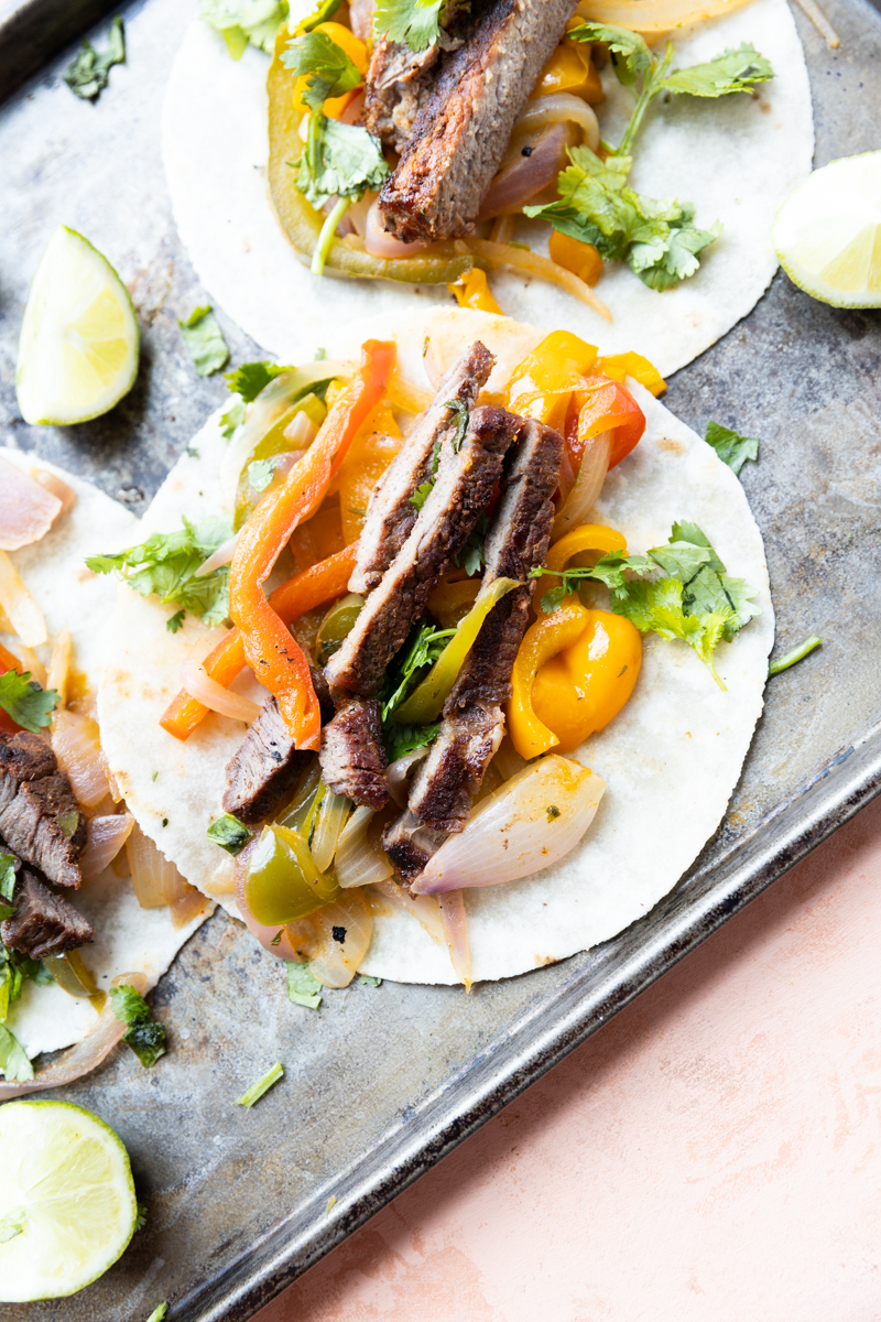 Steak Fajita tacos with slices of lime and fresh cilantro.