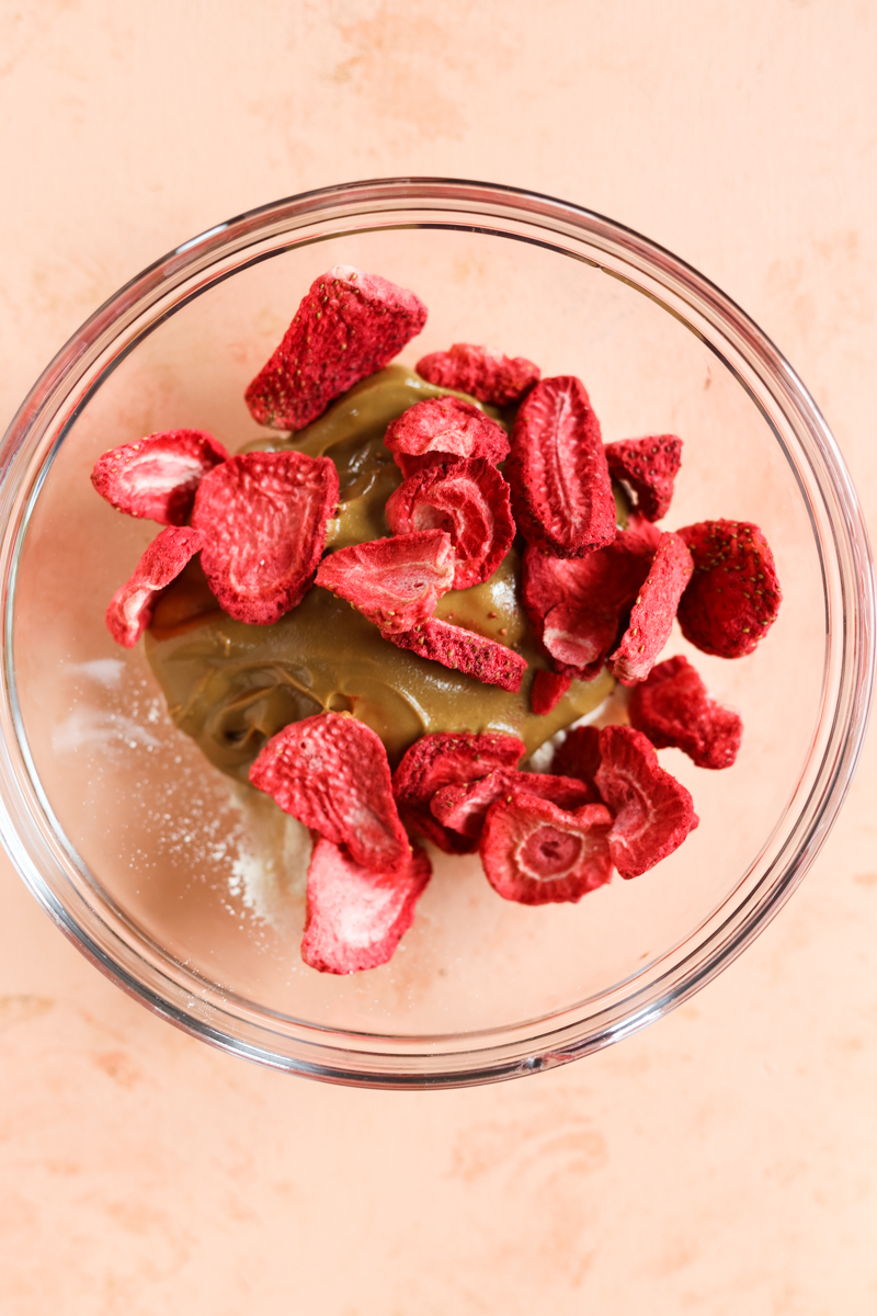 Freeze dried strawberries in a bowl with cashew butter and collagen.