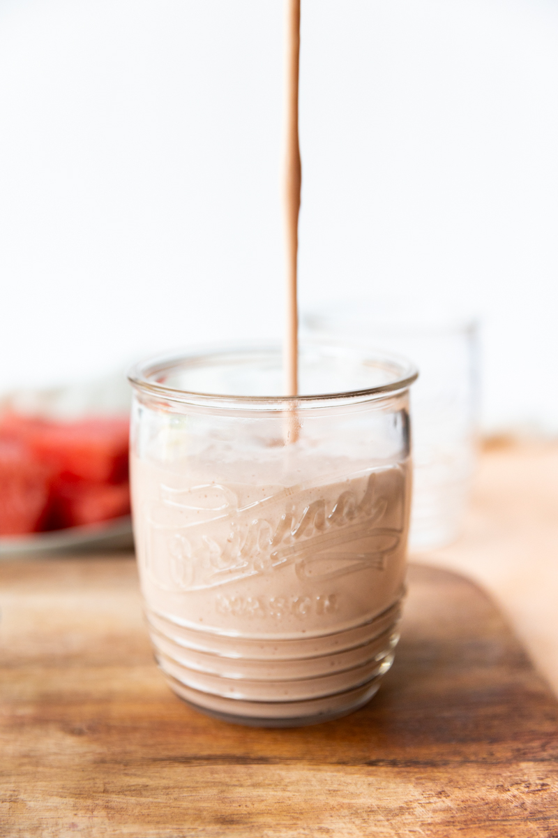 Watermelon banana smoothie being poured into a cup.
