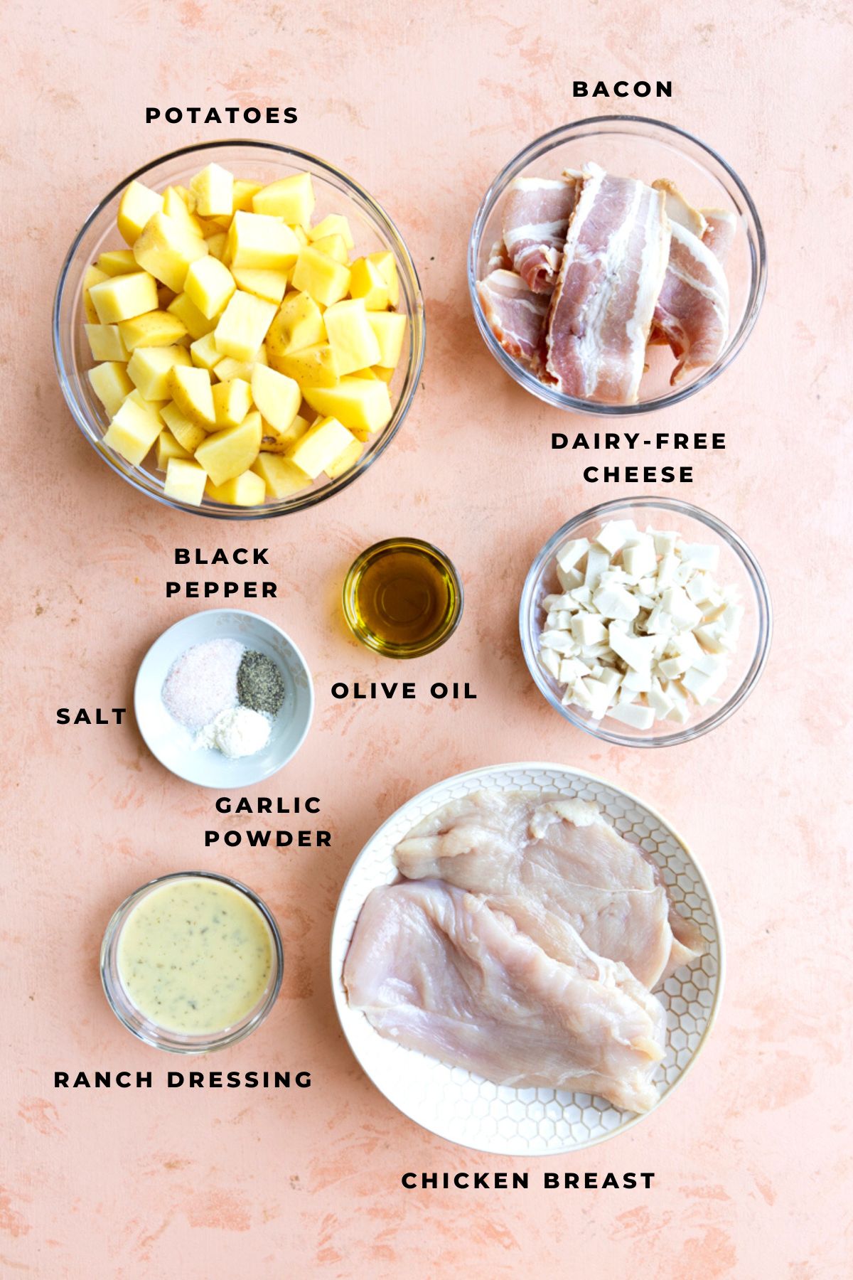 Potatoes, bacon, dairy-free cheese, chicken breast, ranch dressing, olive oil, and spices measured out.