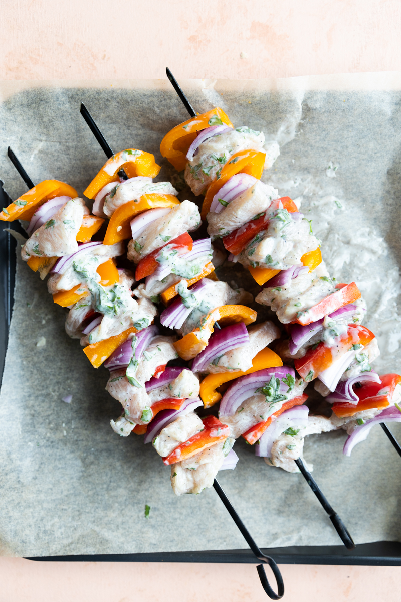 Chicken with bell peppers and red onion on skewers.
