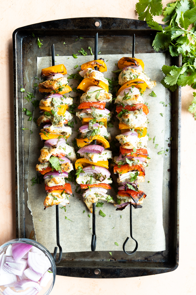Air fried chicken and vegetable kabobs on a baking sheet.