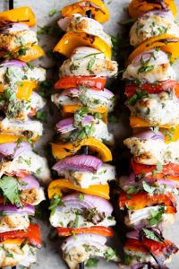 Close up of chicken kabobs with vegetables.