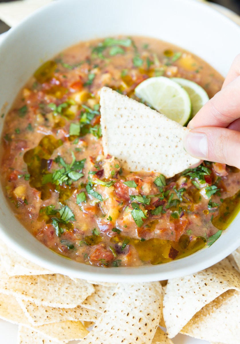 Chip dipping into peach salsa.