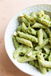 Pasta with pesto in a white bowl.