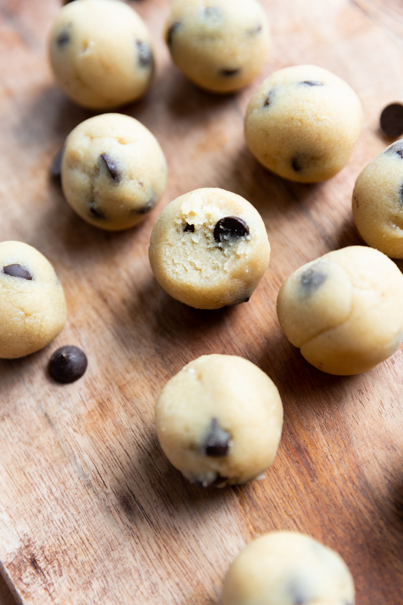 Protein Cookie dough balls with chocolate chips lined up next to each other.