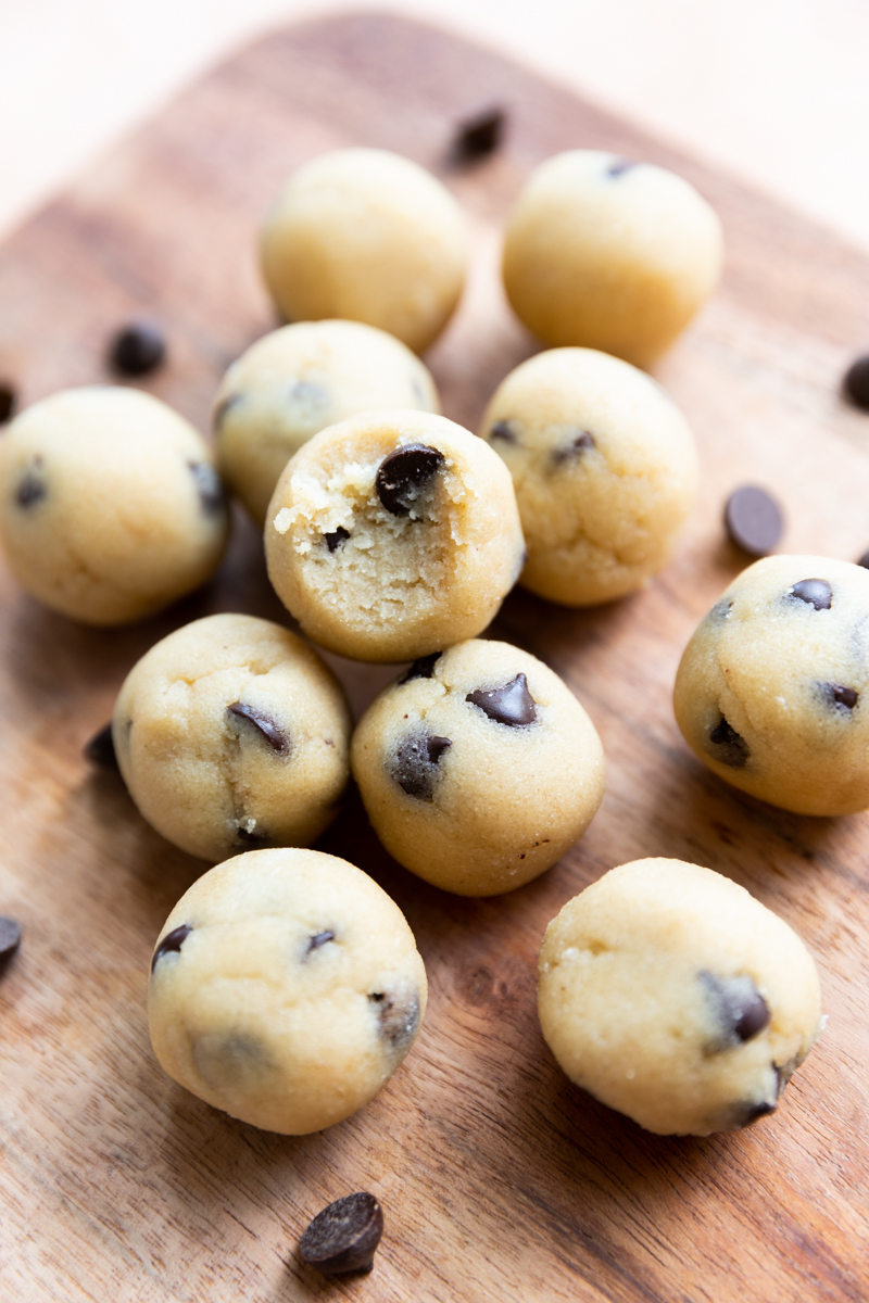 Protein Cookie Dough Balls on a wood board.