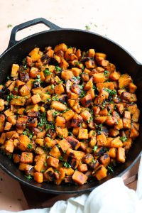 Sauteed sweet potato in a cast iron skillet.