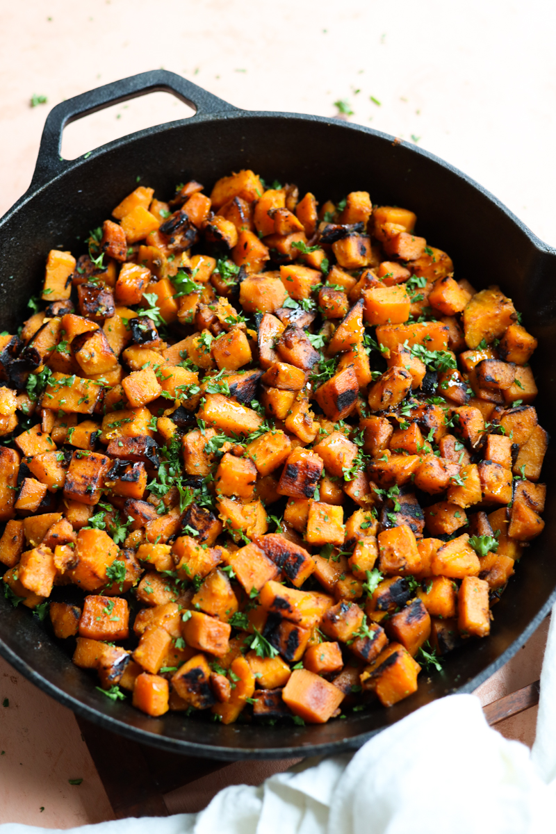 Sauteed sweet potato in a cast iron skillet.