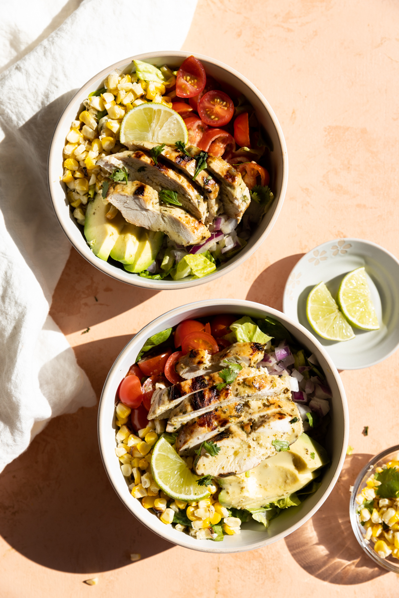 Southwest chicken taco salads with fresh lime wedges.