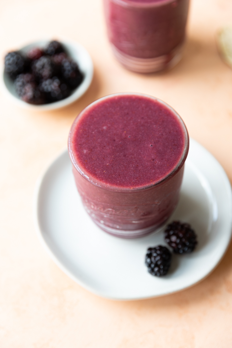 Overhead picture of strawberry banana blackberry smoothie on a plate.