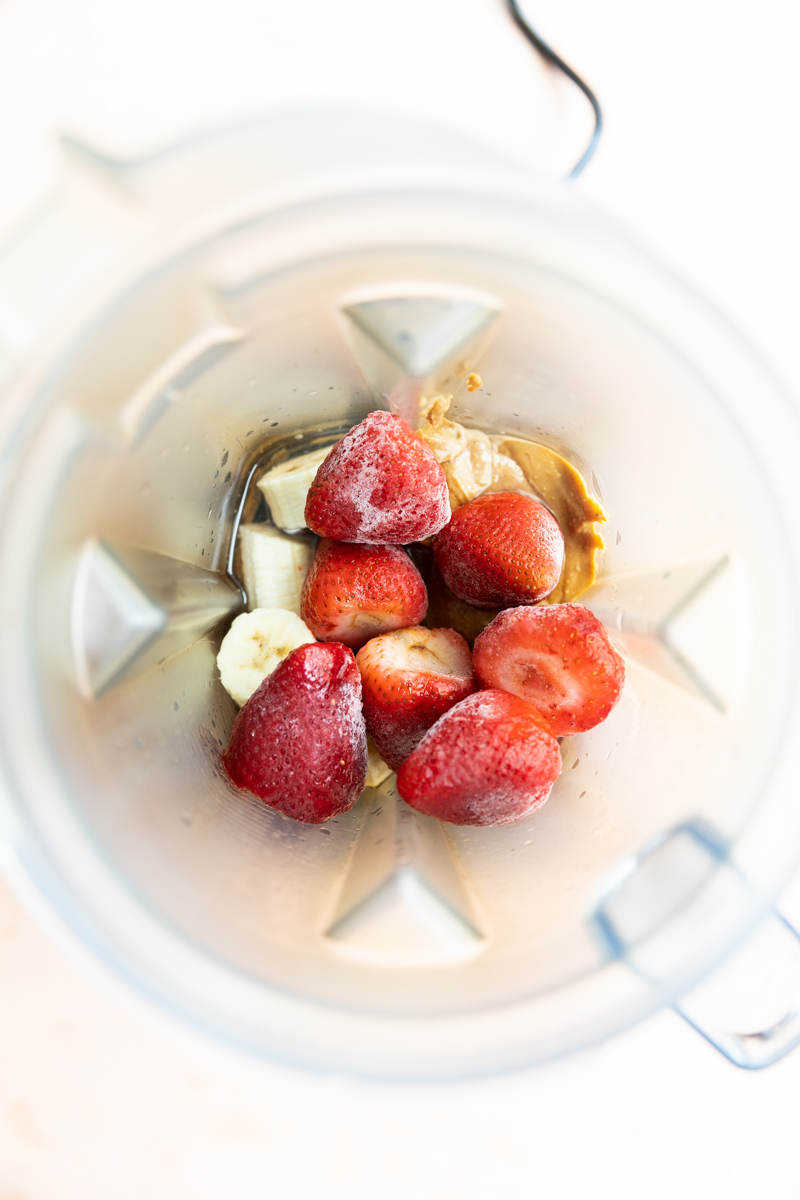 Strawberry banana smoothie ingredients in blender.