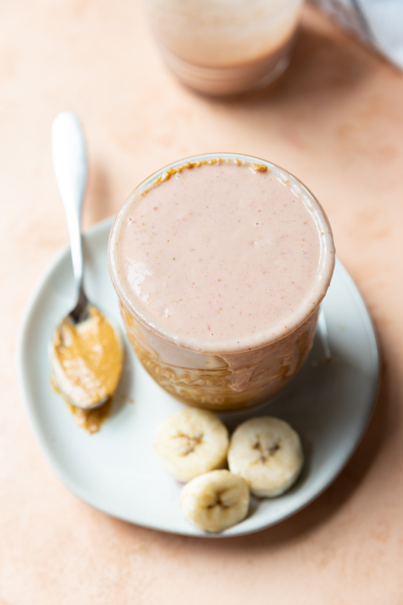 Overhead picture of peanut butter strawberry smoothie in a glass cup.