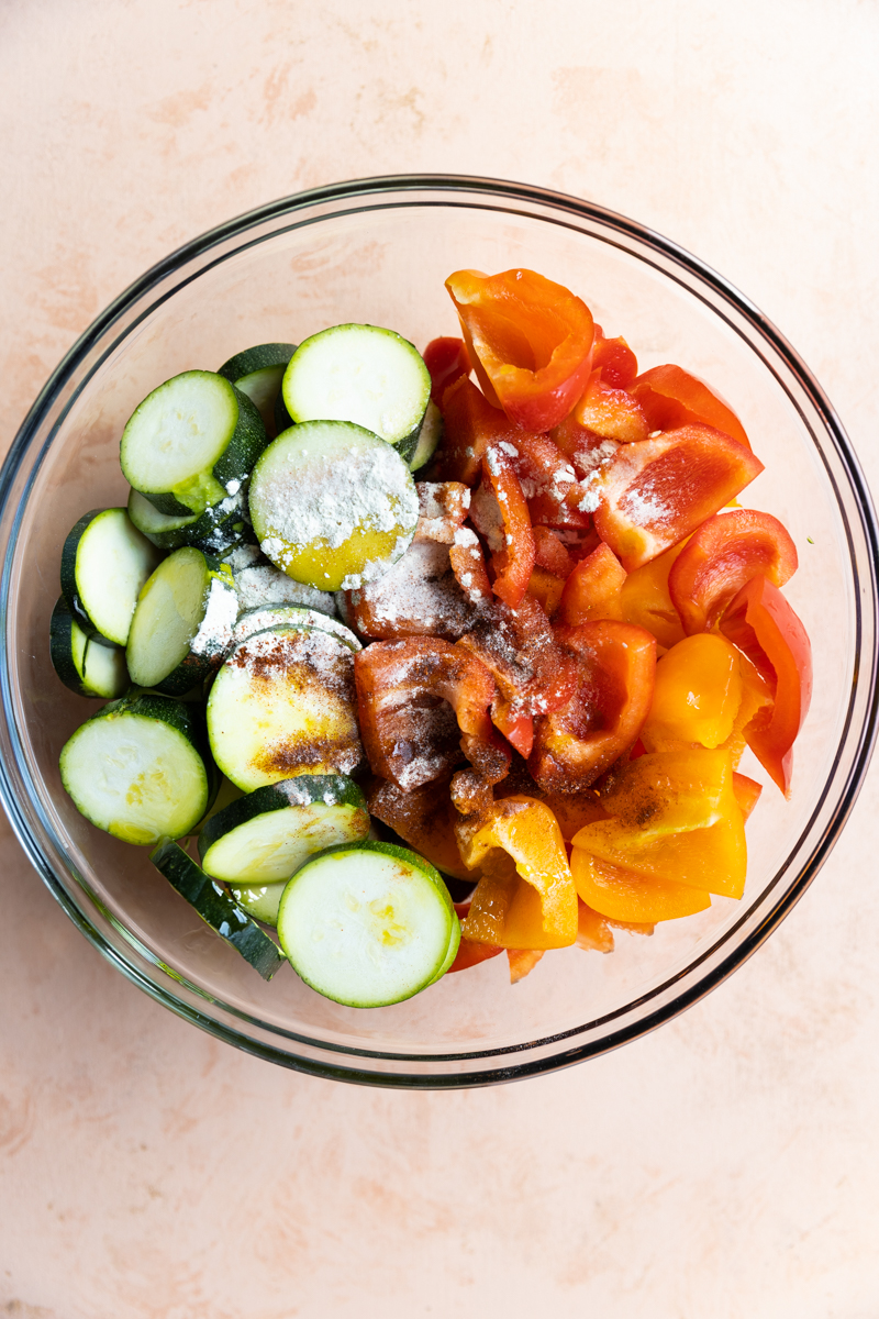 Vegetables in mixing bowl with spices.