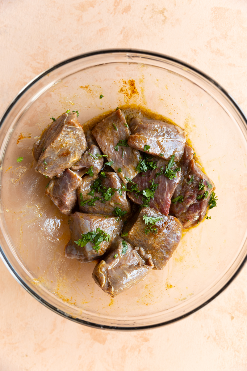 Steak marinating in a bowl.