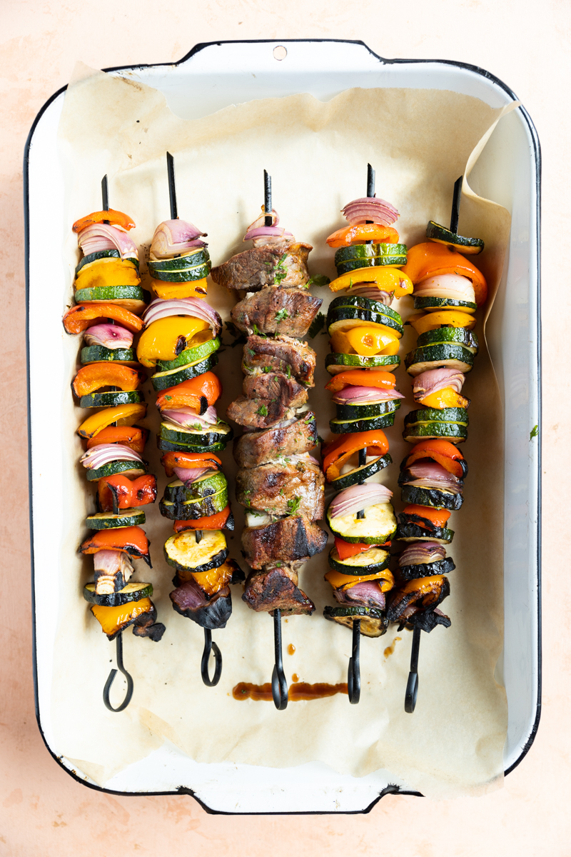 Steak and vegetable skewers with charred edges.