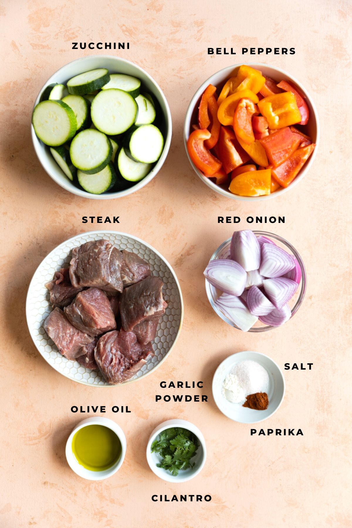 Zucchini, bell peppers, steak, red onions, olive oil, cilantro, and spices.
