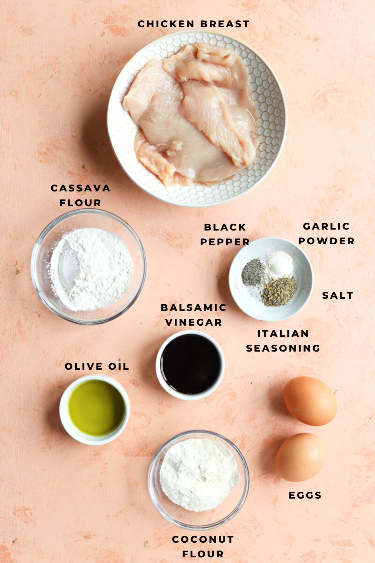 Coconut flour, cassava flour, eggs, vinegar, olive oil, spices, and chicken breast measured out.