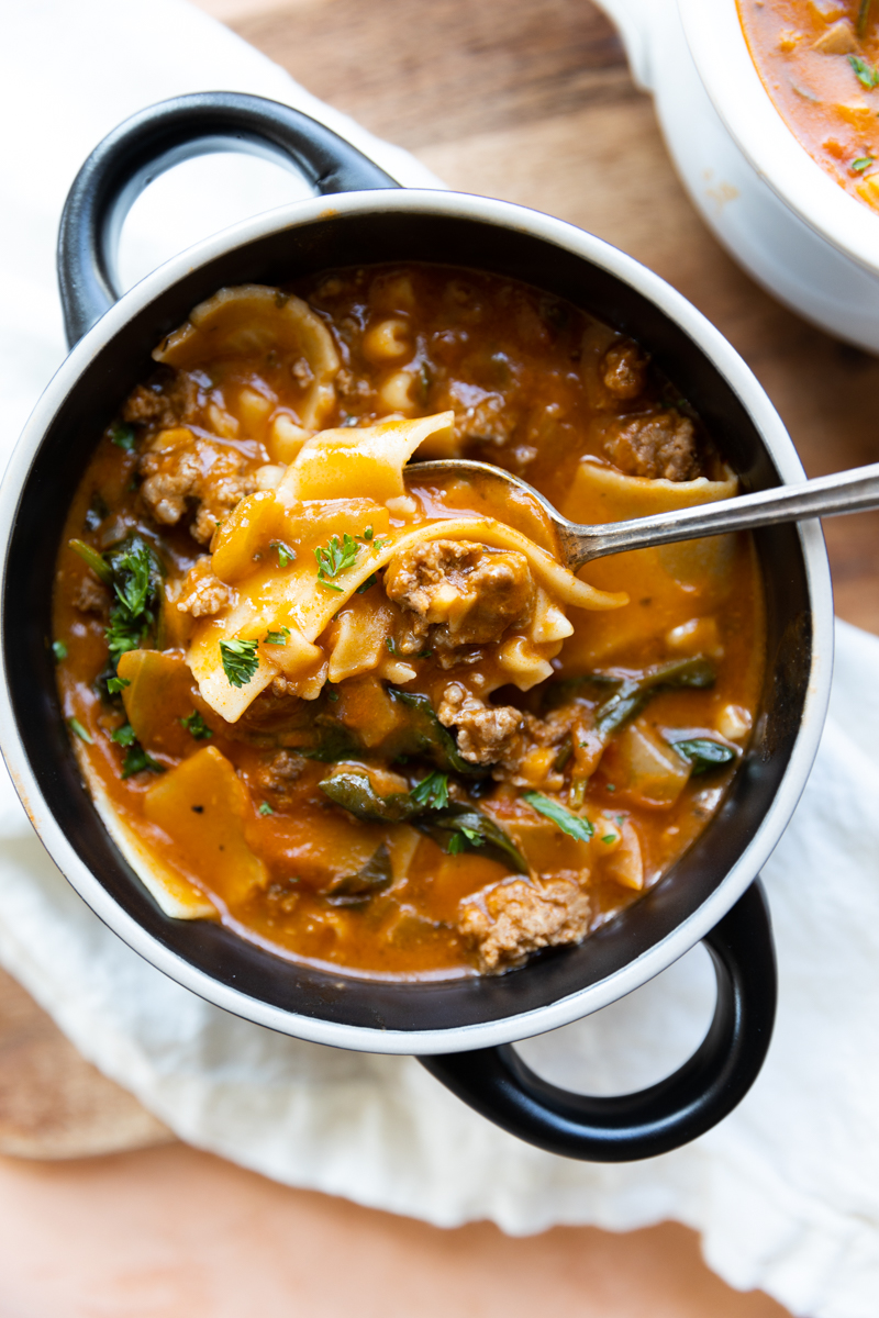 Overhead picture of lasagna soup in a black bowl.