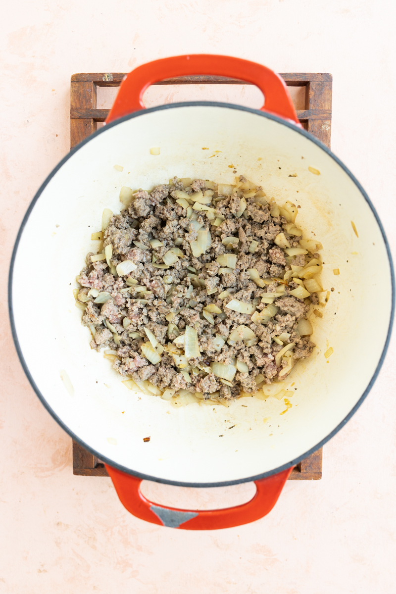 Ground beef and onions cooking in a dutch oven.