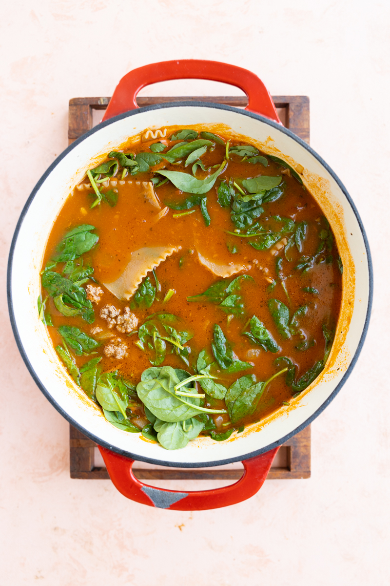 Lasagna soup with cooked noodles and baby spinach.