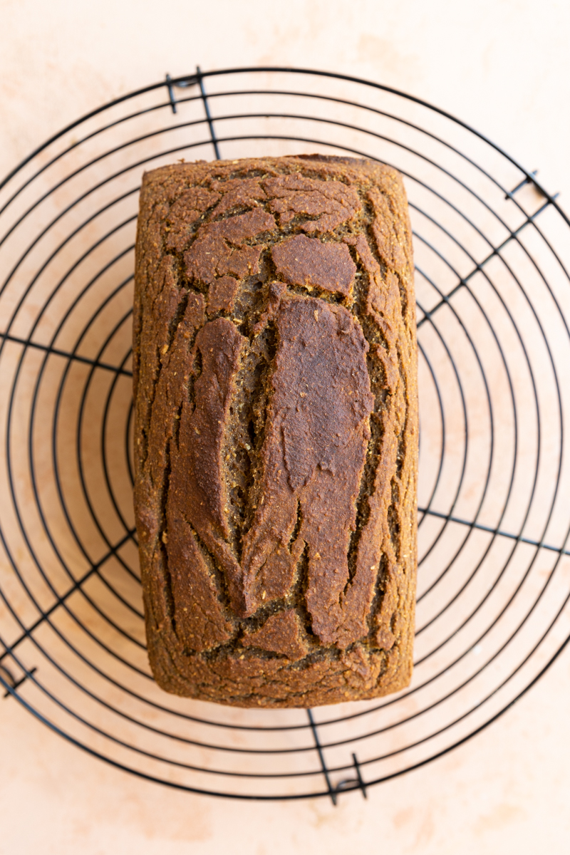 Pumpkin bread cooling on metal rack.