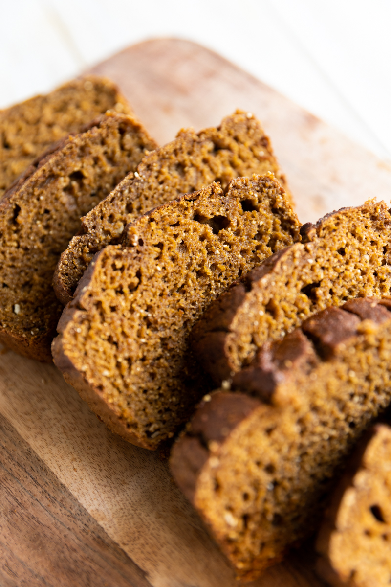 Sliced pumpkin bread on a cutting board.
