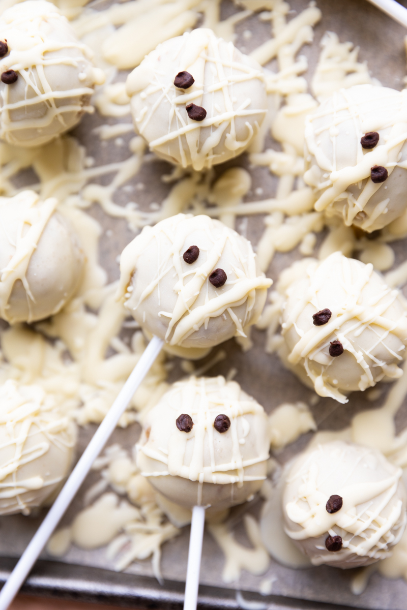 Mummy cake pops on parchment paper.