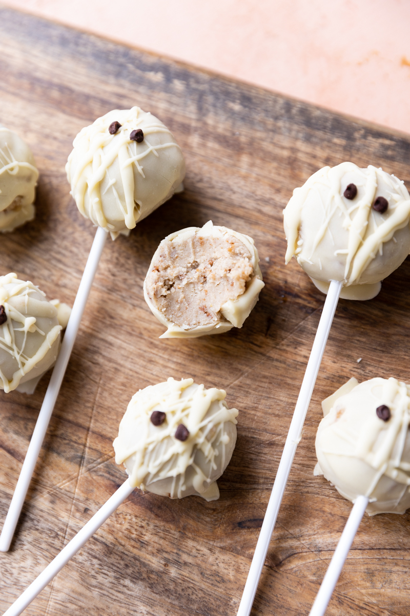 Mummy cake pops on a wood board.
