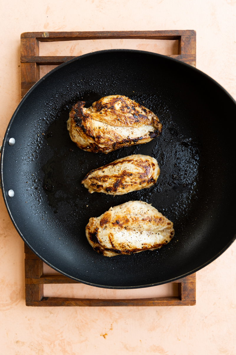 Balsamic chicken breast cooking in skillet.