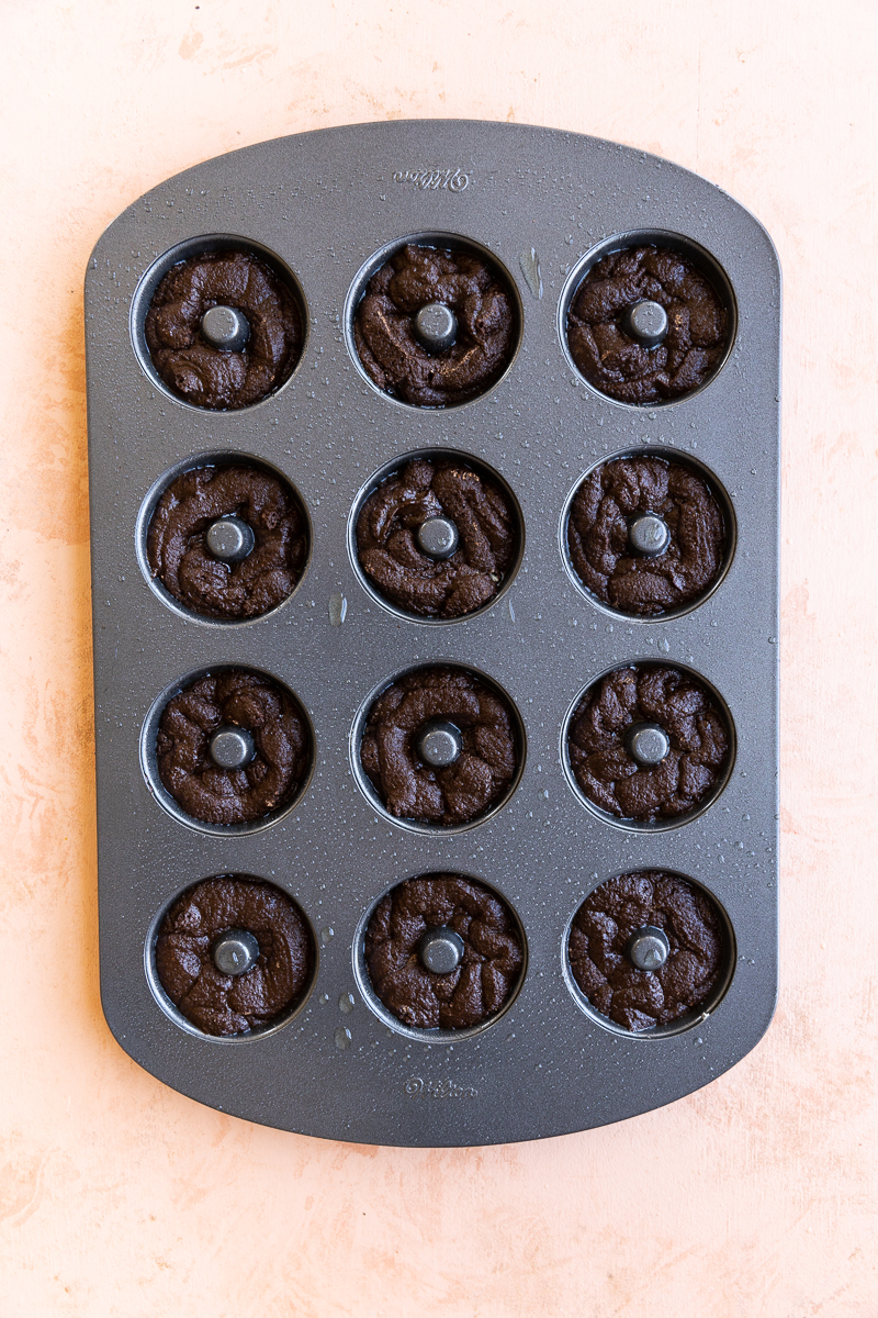 Donut pan filled with chocolate batter.
