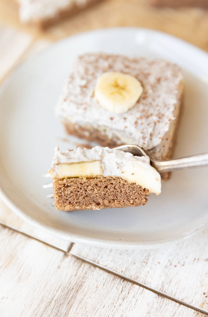 Fork scooping big bite of banana cream pie bar.
