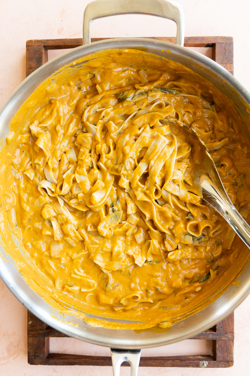Fettucine mixed into creamy pumpkin pasta sauce.