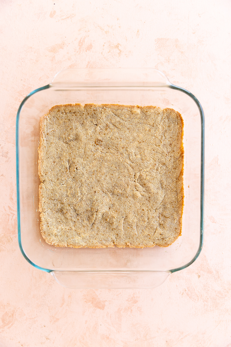 Baked pumpkin pie crust in square baking dish.