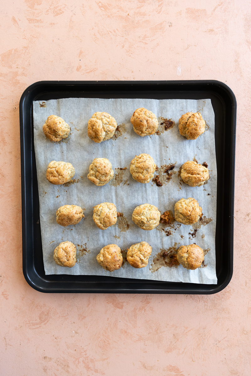 Cooked Chicken meatballs on baking sheet.