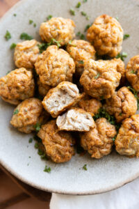 Chicken meatballs on a plate with one cut in half.
