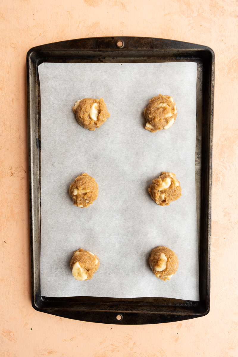 Banana cookies on parchment paper lined baking sheet.