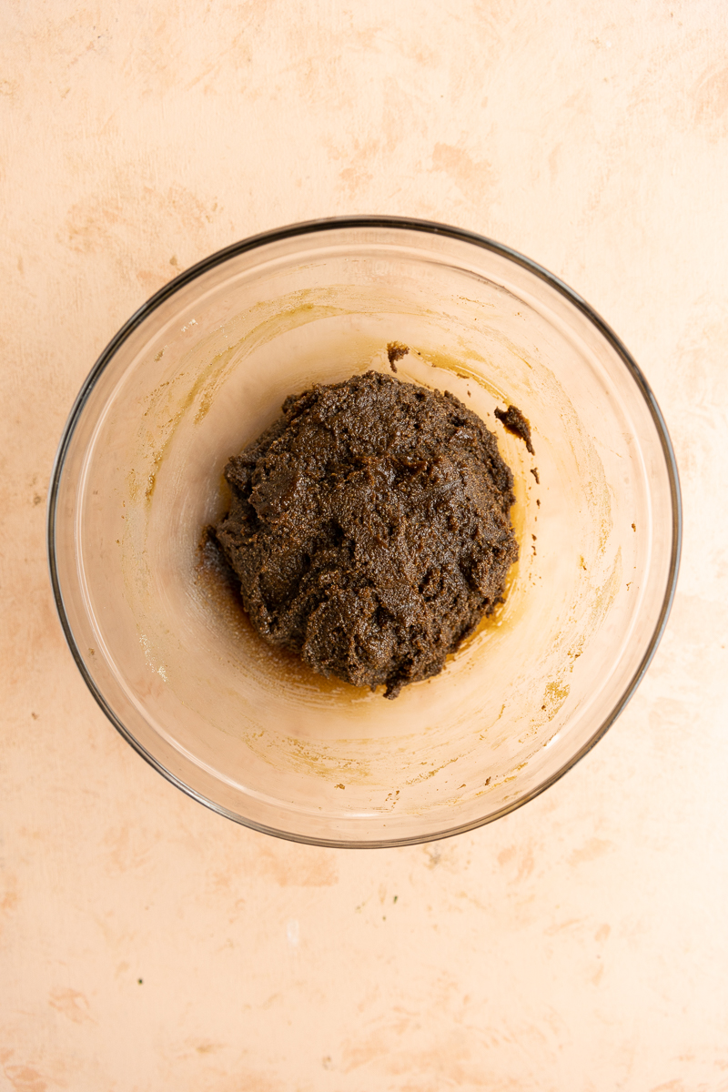 Molasses cookie dough in glass bowl.