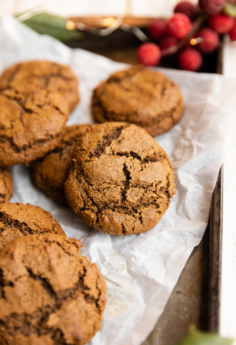 Close up picture of gluten free molasses cookie on parchment paper.