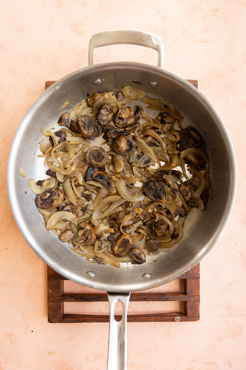 Caramelized onions and mushrooms in a pan.