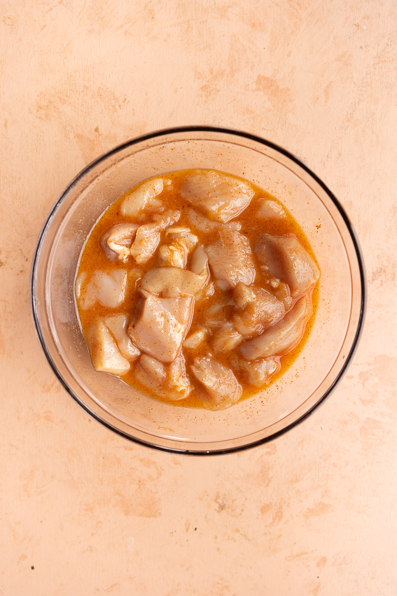 Chicken marinating in mixing bowl.