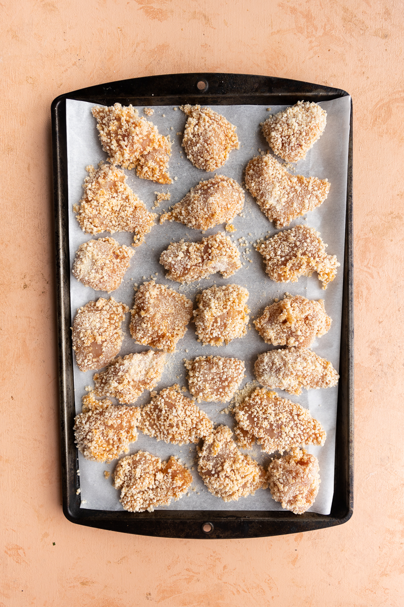 Breaded chicken on a baking sheet.