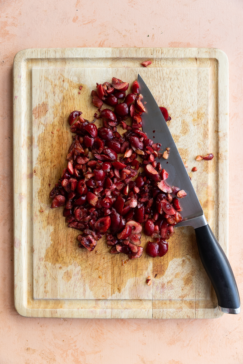 Chopped cherries on a cutting board.
