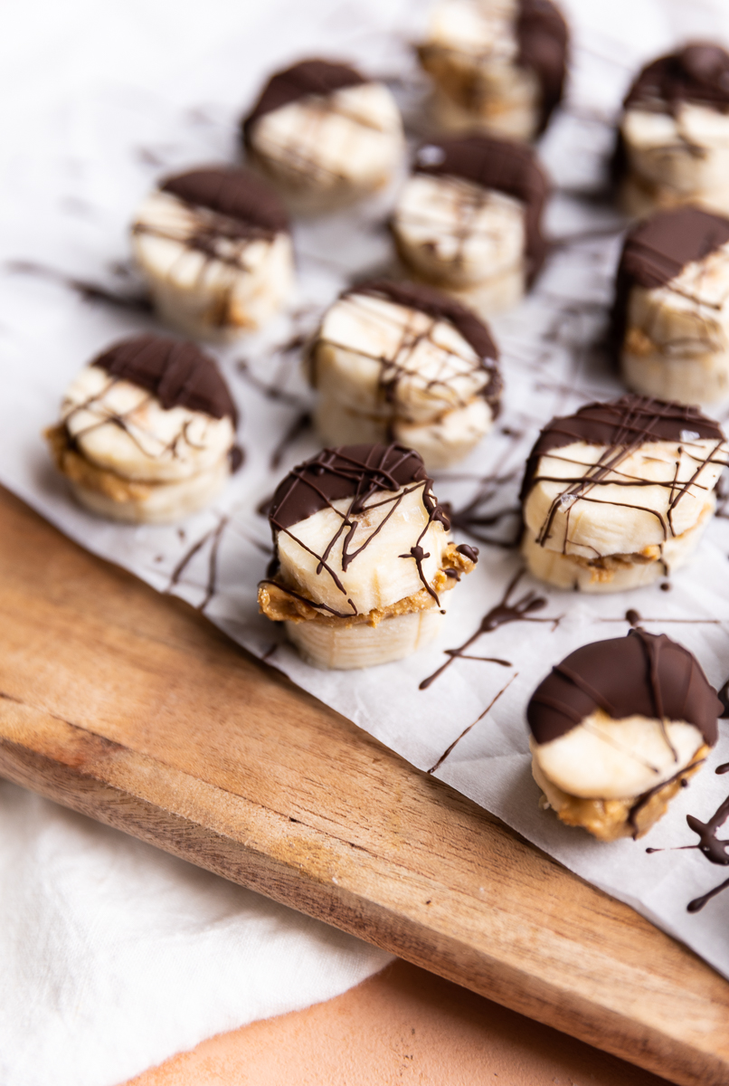 Frozen banana bites with dark chocolate drizzled on top.