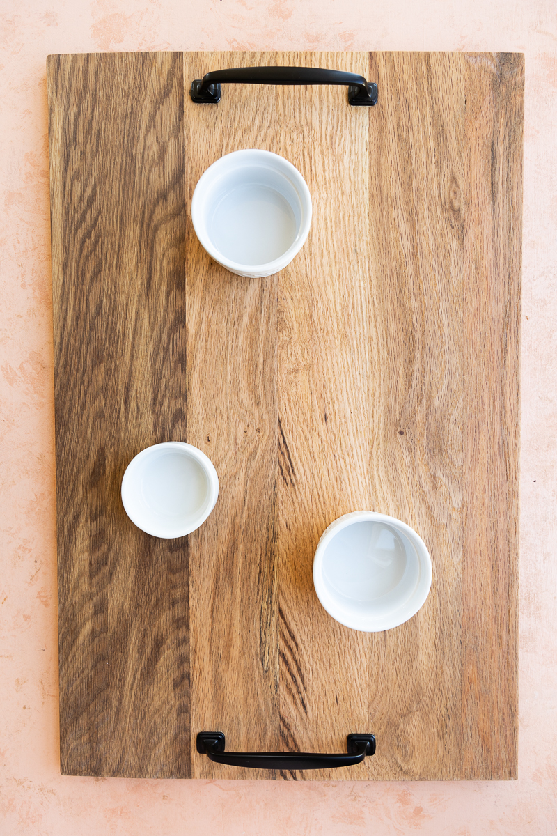 Wooden board with white bowls.