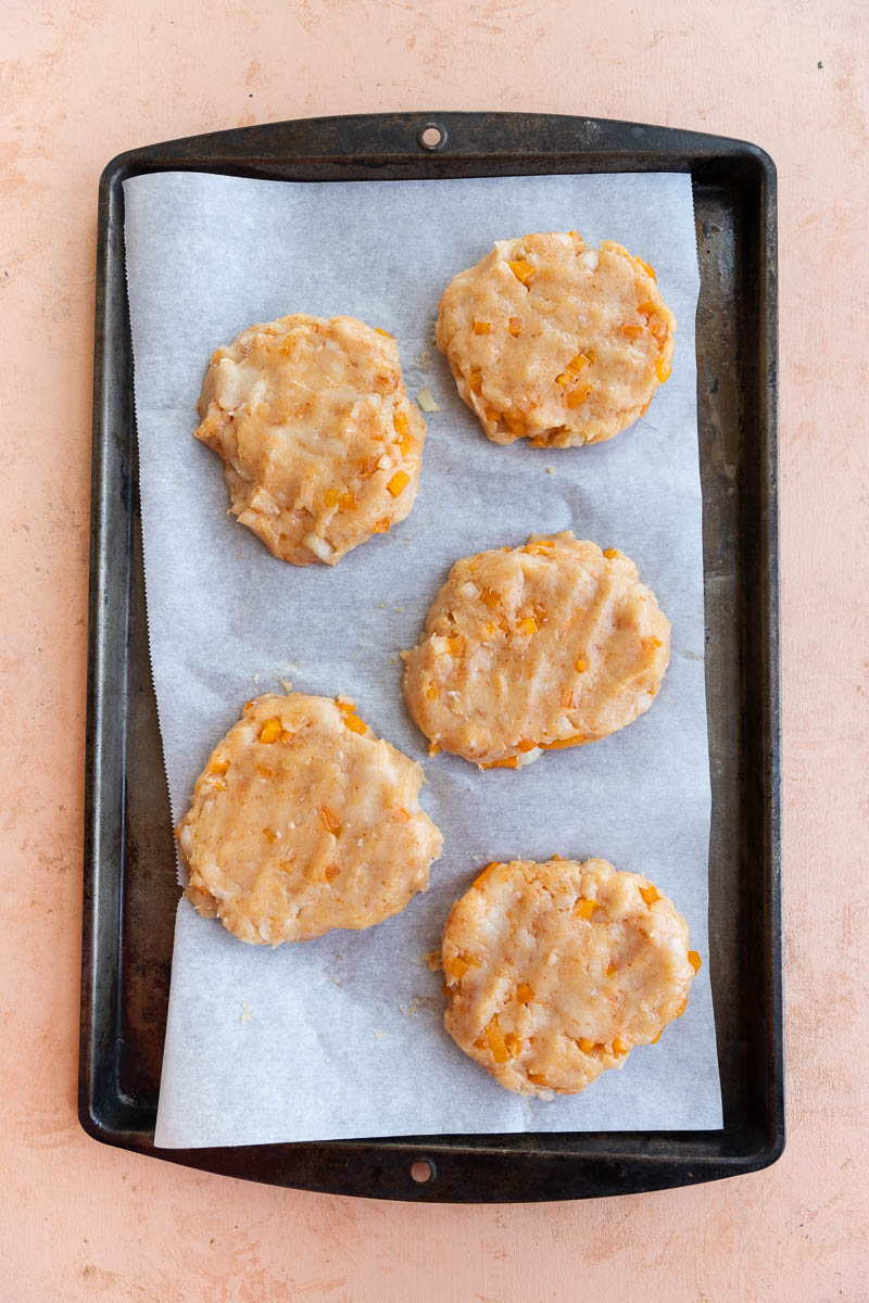 Five chicken patties on parchment paper.